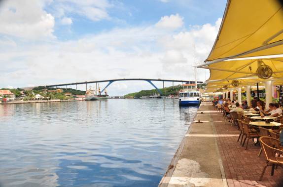 Restaurantes na beira do canal em Willemstad - Curaçao. Ao fundo, a famosa ponte Rainha Juliana